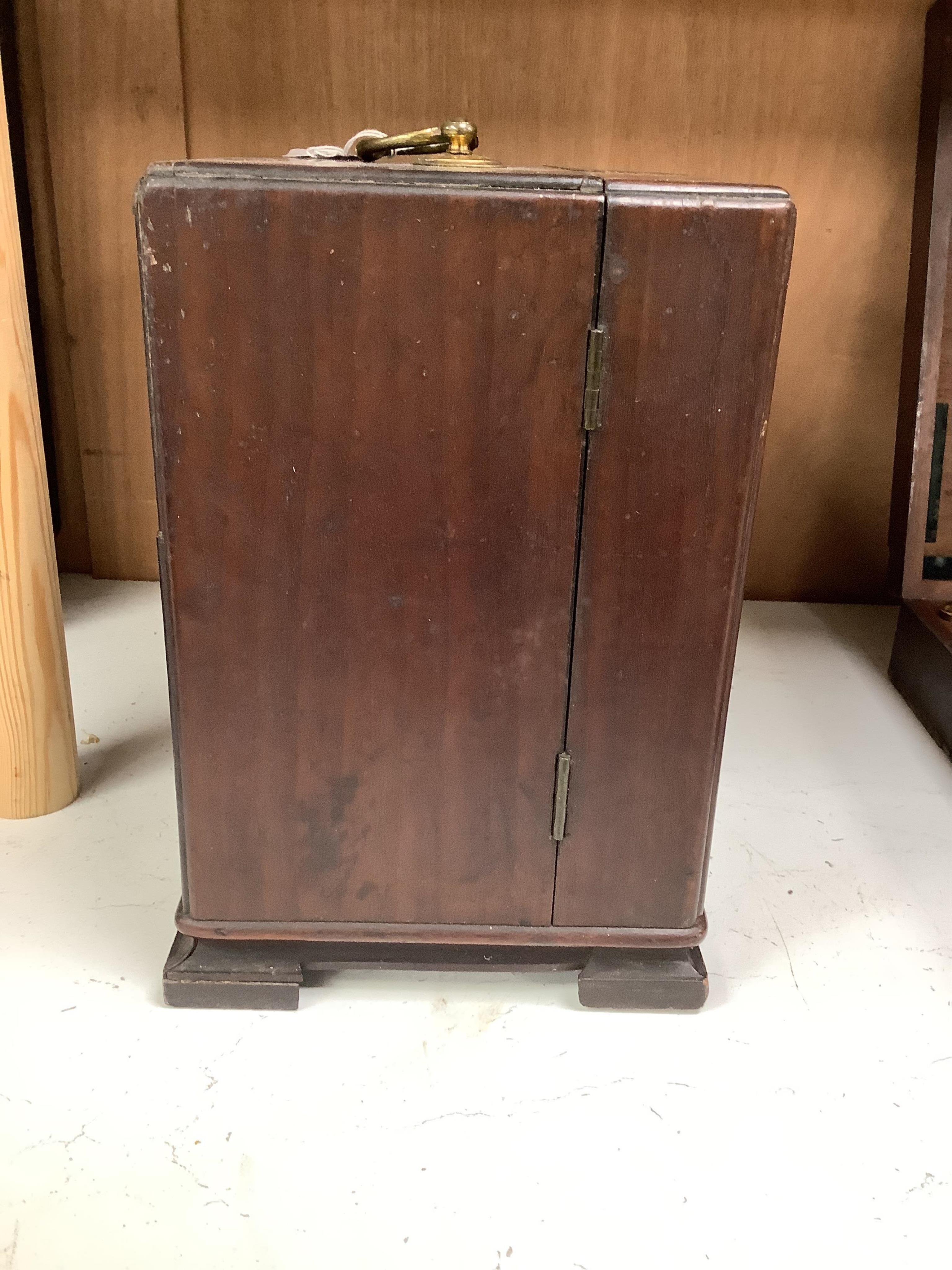 A 19th century mahogany apothecary cabinet, containing 20 bottles of various medicinal compounds and poisons, some sealed, all with paper labels, mainly for ‘C. Woollven, Operative & Dispensing Chemist, 108, High Street,